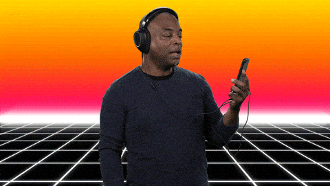 LaVar Burton on an early computer graphics check background with headphones on turning to the camera and saying 